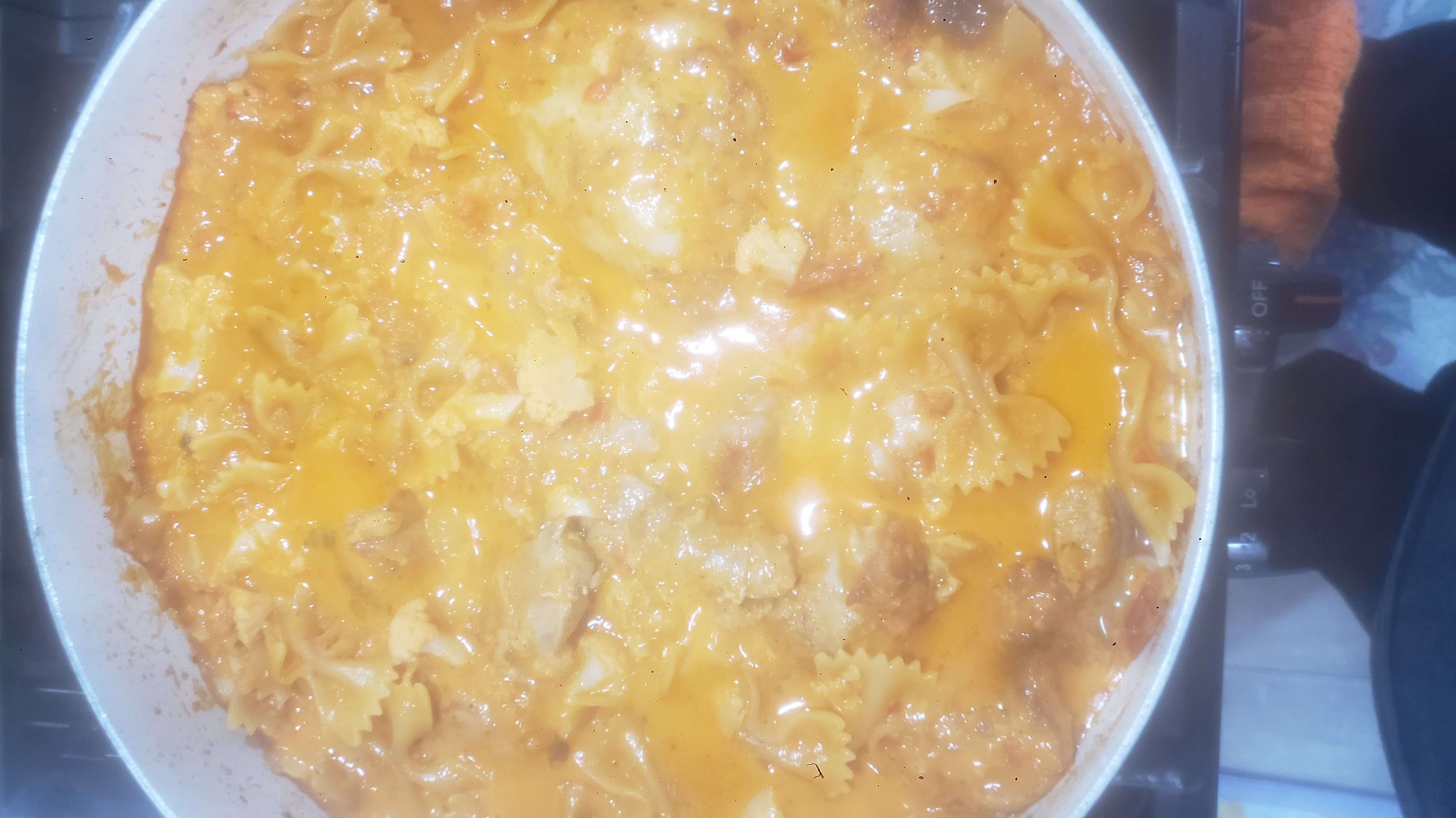 Pasta dish in a pan on a stove.
